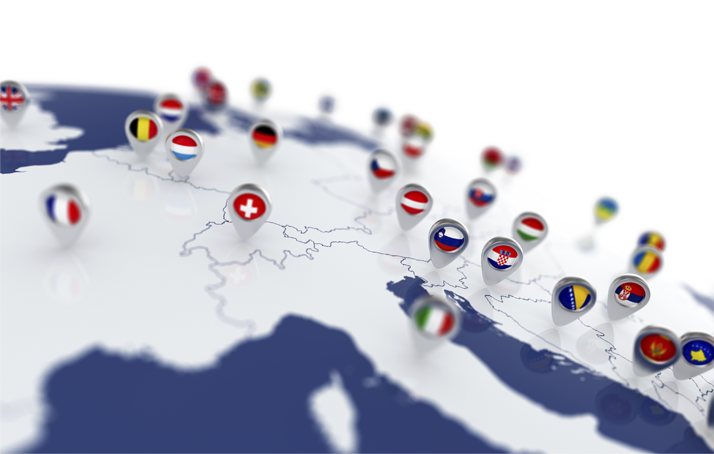 Eine Weltkarte mit mehreren Stecknadeln an verschiedenen Ländern. Die Stecknadeln haben jeweils die Flagge drauf.