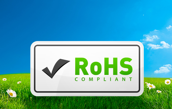 Ein weißes Schild mit dem RoHS Logo auf einer grünen Wiese mit blauem Himmel.