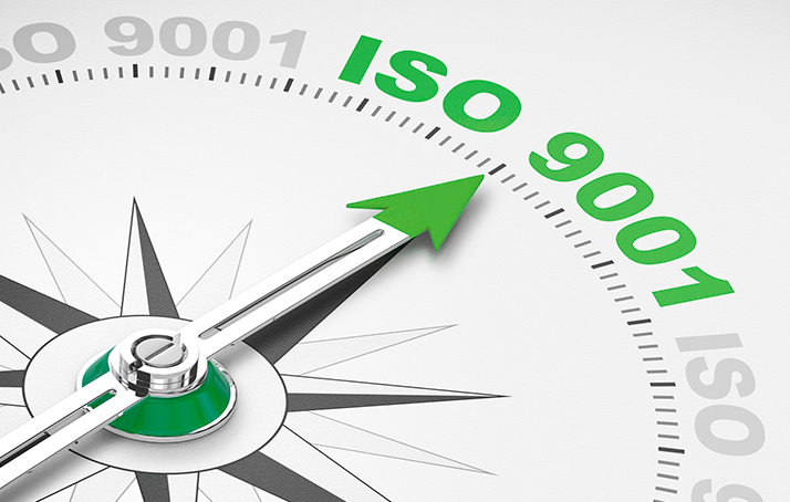 Ein Kompass mit einem grünen Zeiger welcher auf ISO 9001 zeigt.