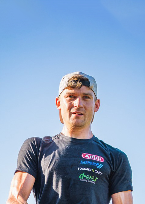 Ein Portrait von Profi-Triathlet Samuel Boettinger unter blauem Himmel